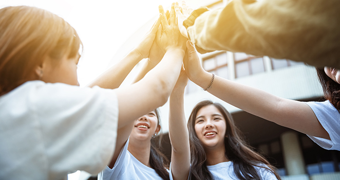 happy students giving high five at school